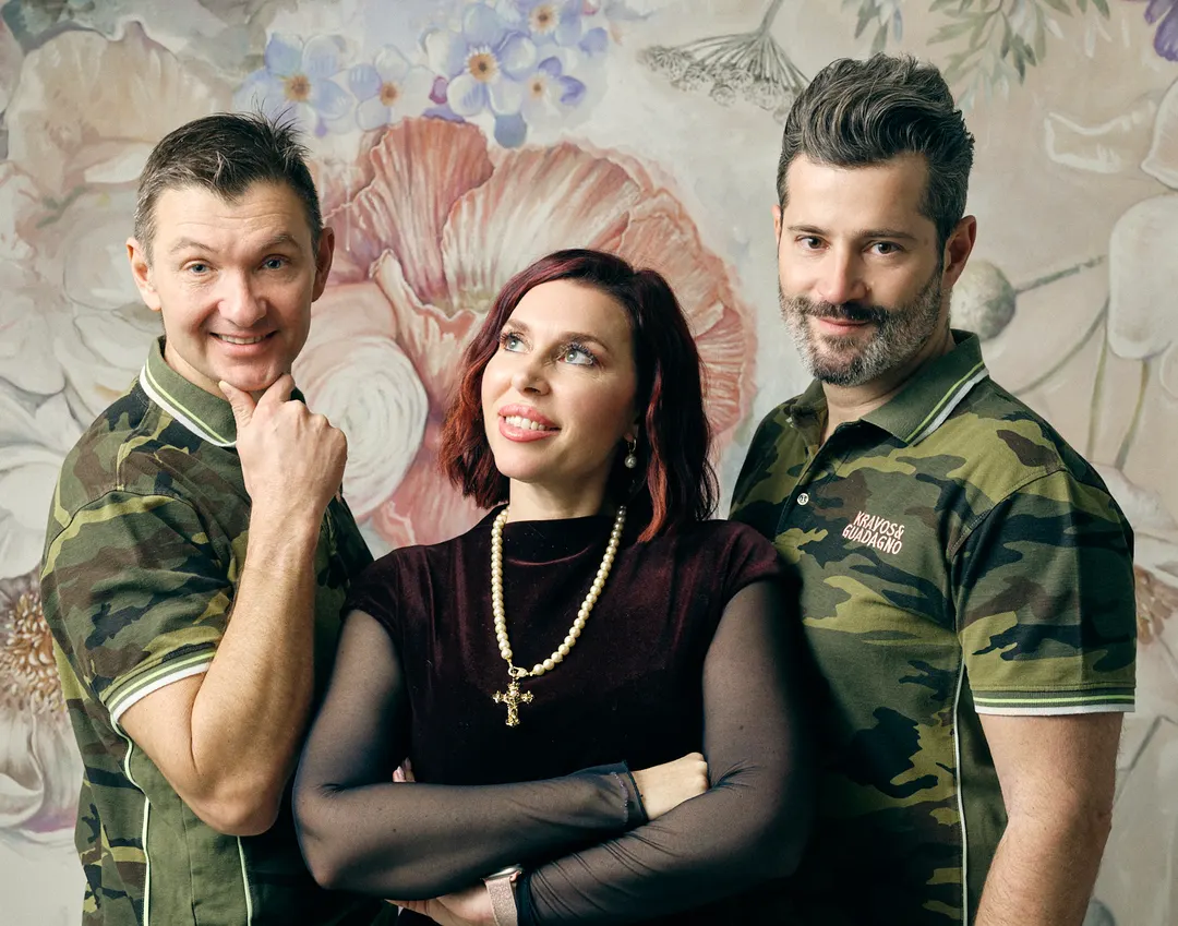 Simone Kravos, Michela Pocecco e Francesco Guadagno davanti a una parete dipinta a fiori