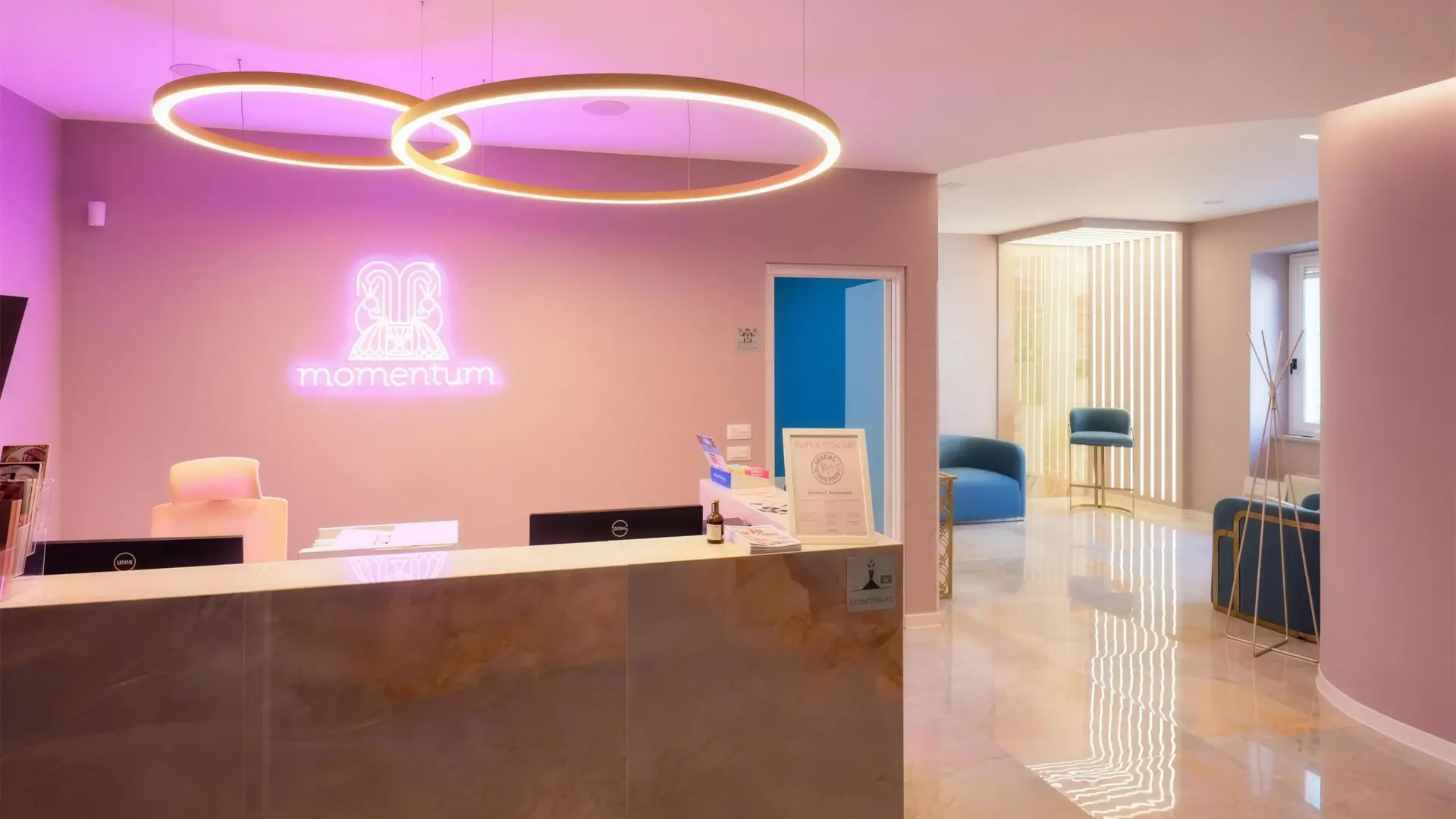 La reception di Momentum: le pareti rosa, l'insegna al neon e il lampadario dei due anelli d'oro