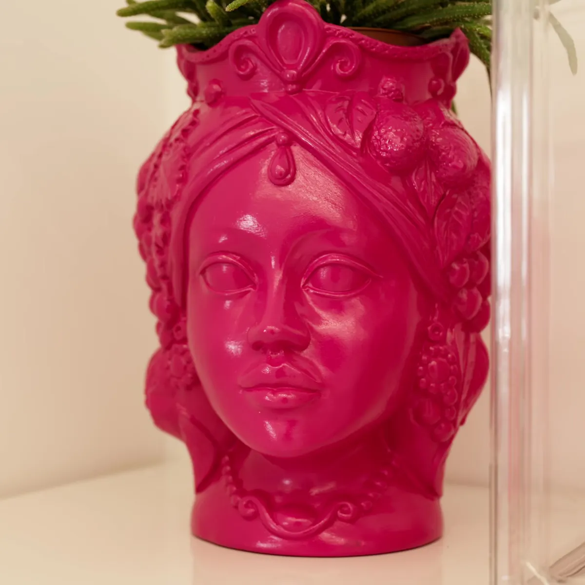 Una testa di moro in ceramica fucsia sul banco della reception